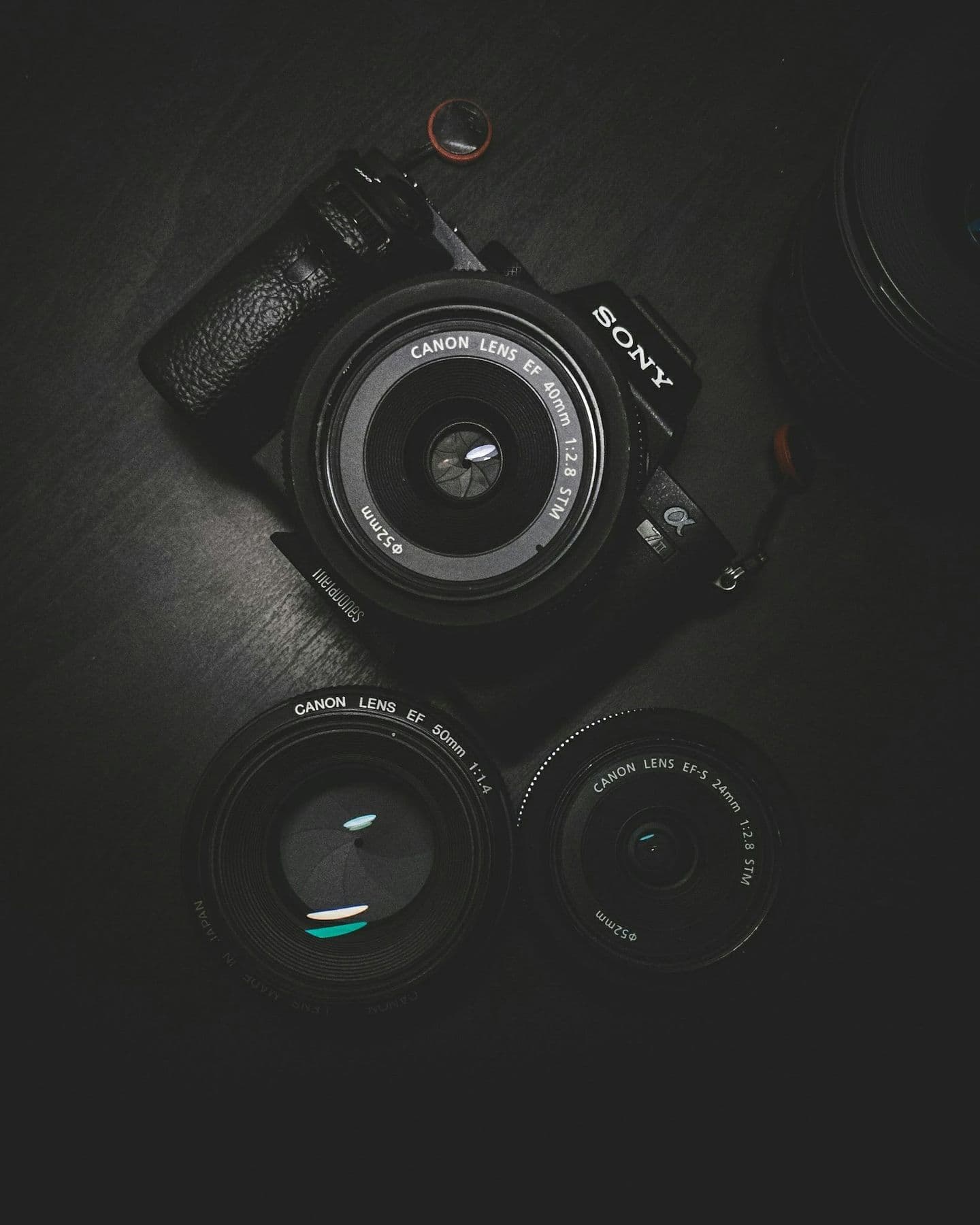 Camera body and lenses on a dark surface