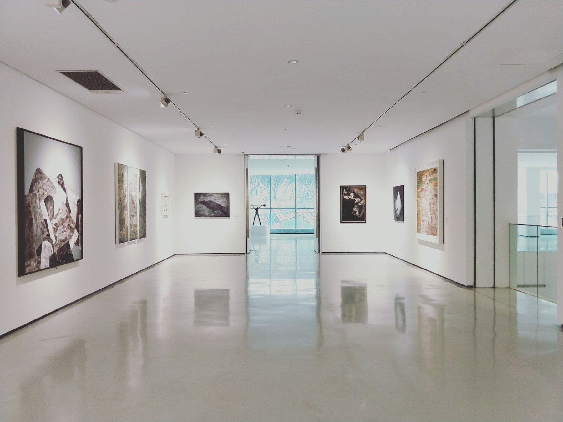 Empty white gallery with framed works on the walls