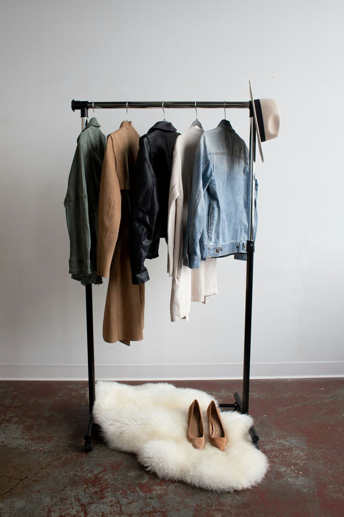 Clothing rail with coats and denim above a sheepskin rug