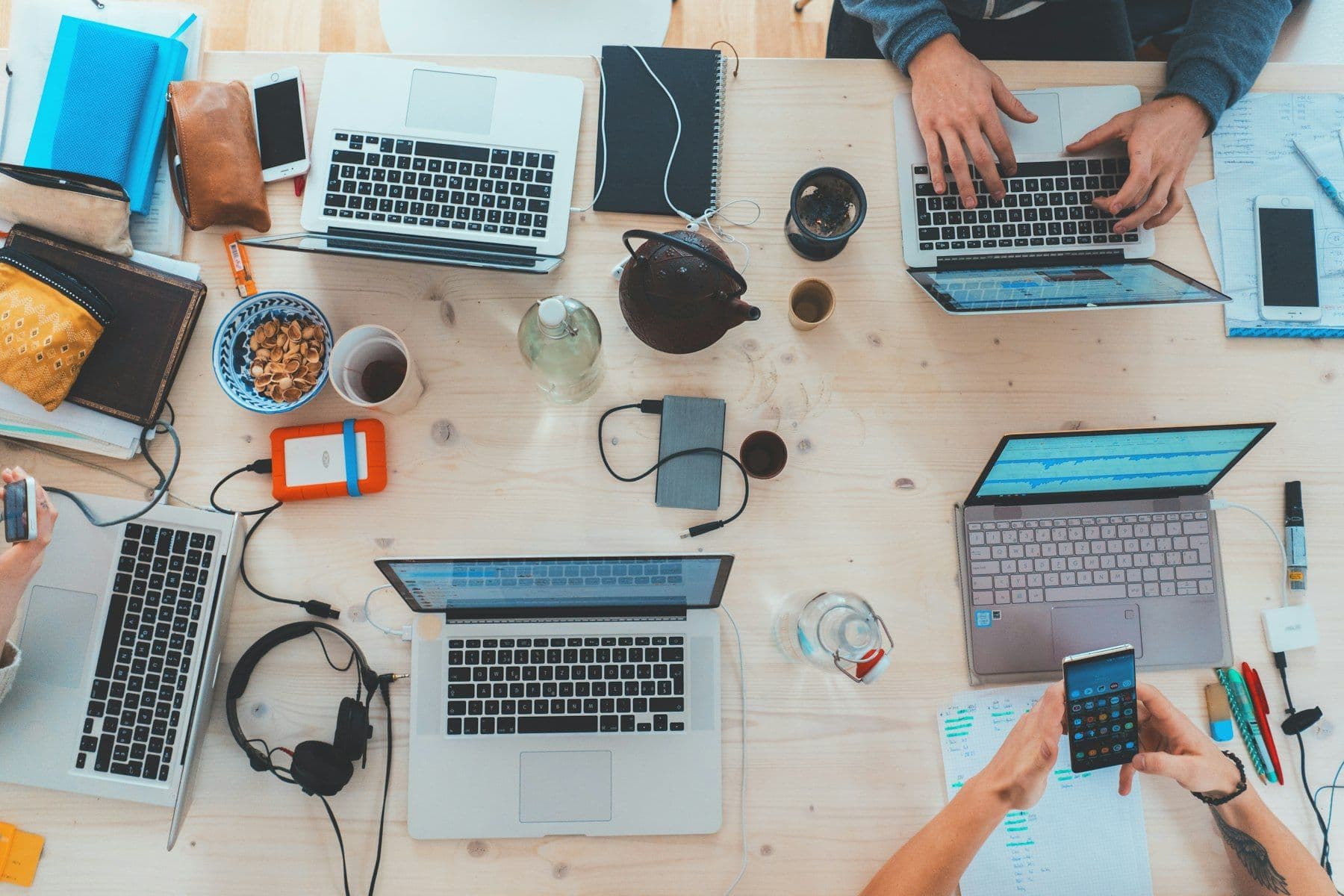 People working on laptops around a shared table
