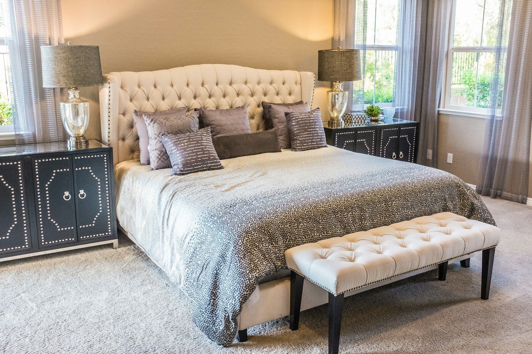 Softly lit bedroom with upholstered headboard and bench